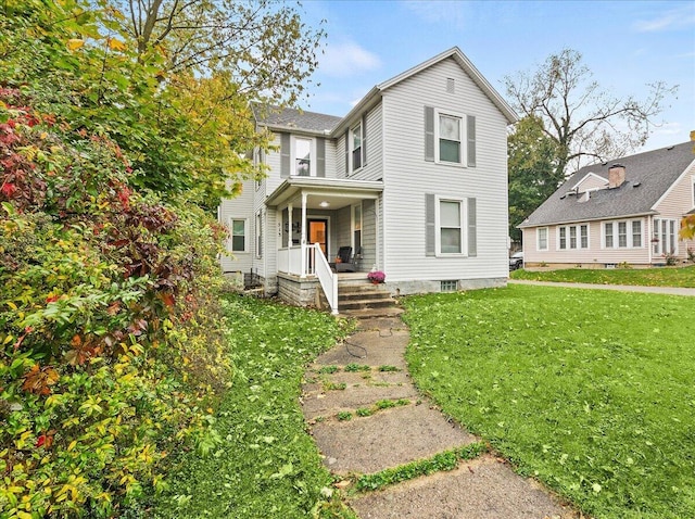 traditional-style house featuring covered porch and a front yard