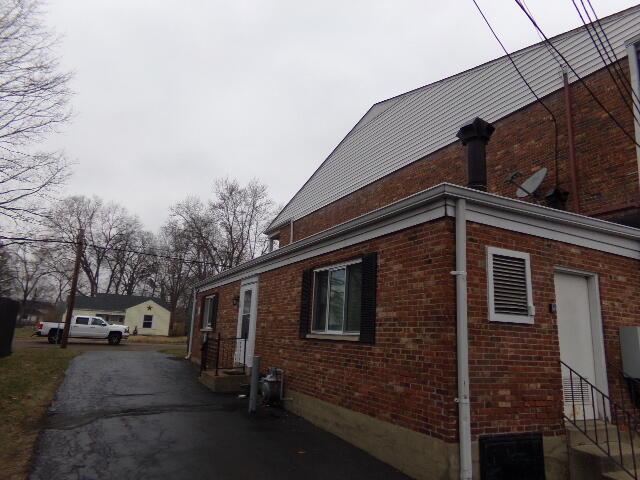 view of property exterior with entry steps and brick siding