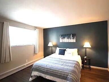 bedroom with wood finished floors and baseboards