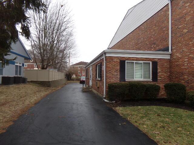 view of home's exterior with brick siding and fence