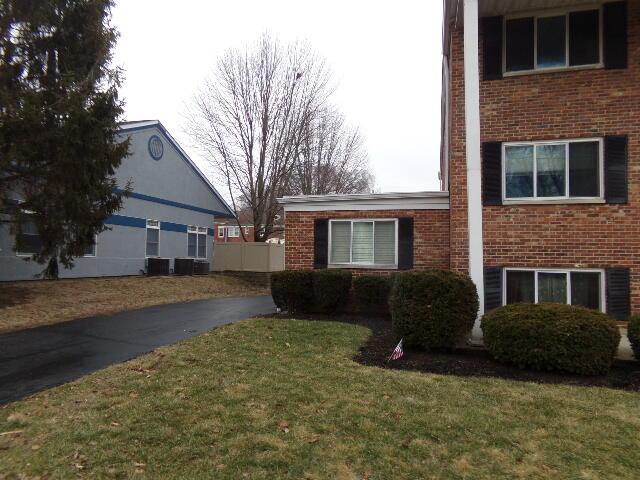 view of property exterior with a lawn and brick siding