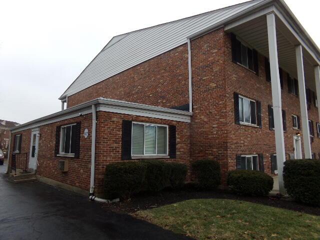 view of side of home with central AC and brick siding