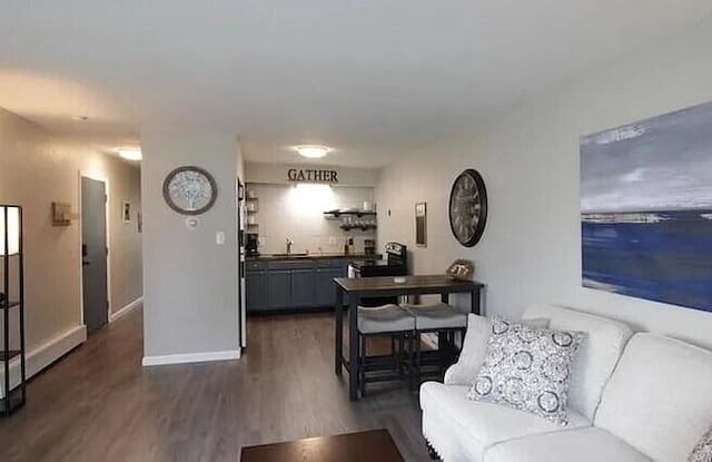 living room featuring baseboards and dark wood-style flooring