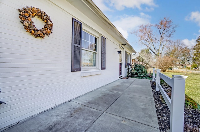 view of home's exterior with a patio area and brick siding