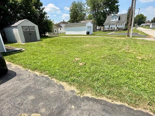 271 N Ludlow St, Covington, OH 45318 - view of green lawn featuring a shed, a detached garage, and a residential view