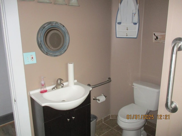 bathroom featuring vanity, tile patterned floors, and toilet