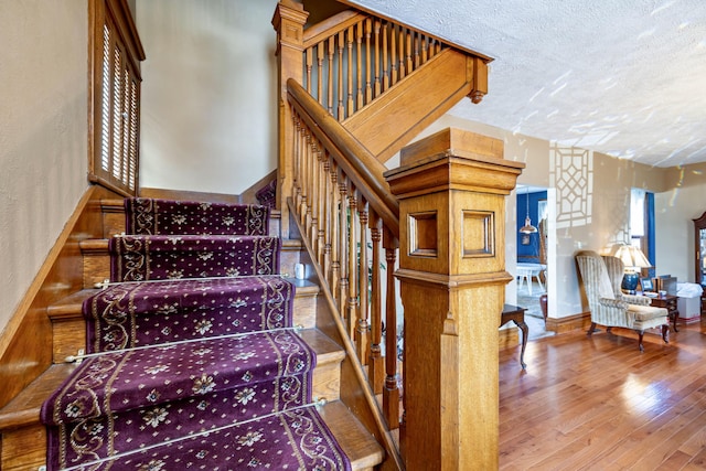 103 N Boggs St, De Graff, OH 43318 - staircase featuring a textured ceiling and wood finished floors