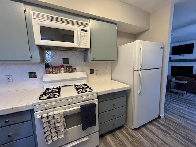 7824 Maple St, Russells Point, OH 43348 - kitchen featuring white appliances, dark wood finished floors, decorative backsplash, and tile counters