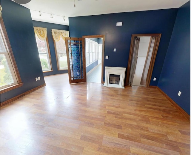 612 W Spring St, Saint Marys, OH 45885 - unfurnished living room with light wood-type flooring, baseboards, a fireplace, and ceiling fan