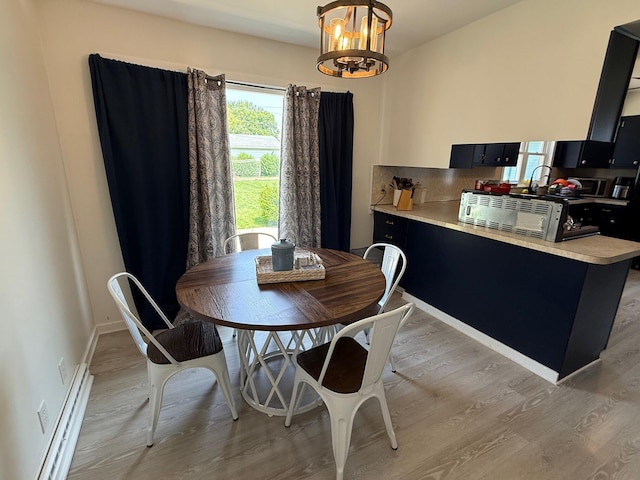 612 W Spring St, Saint Marys, OH 45885 - dining space with baseboard heating, light wood-style floors, and a chandelier