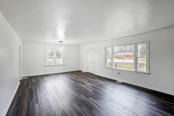 interior space with a wealth of natural light and dark hardwood / wood-style floors