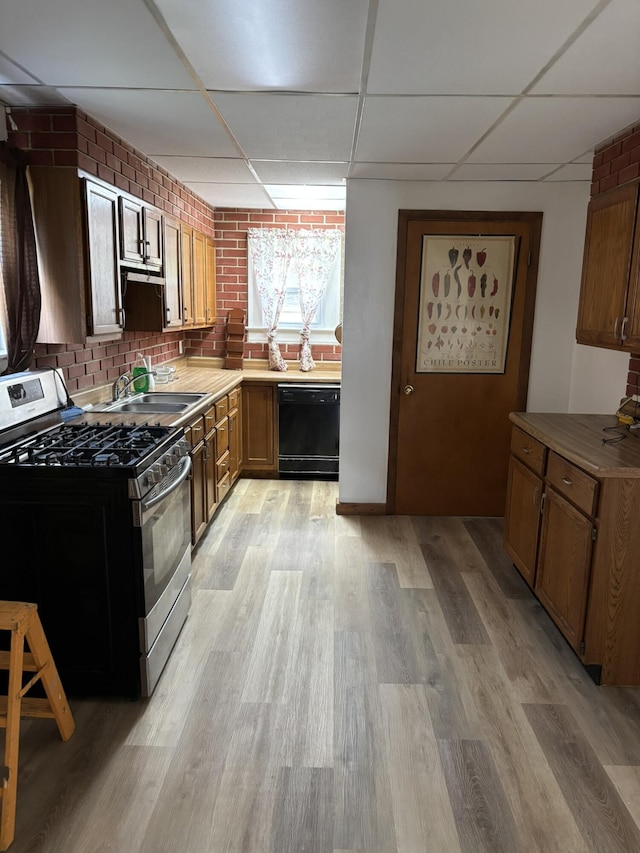 320 N Clairmont Ave, Springfield, OH 45503 - kitchen featuring gas stove, black dishwasher, a drop ceiling, and light wood-style floors