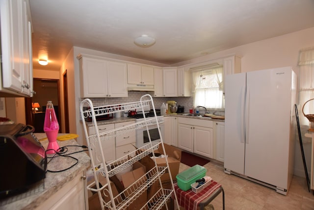 kitchen featuring white cabinets, white refrigerator, sink, and tasteful backsplash