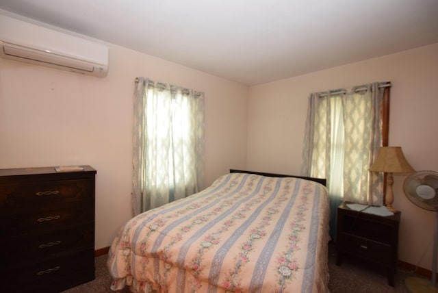 bedroom featuring dark carpet and a wall mounted air conditioner