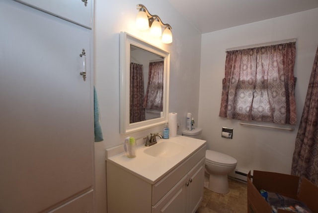 bathroom with toilet, vanity, and a baseboard radiator