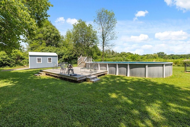 930 N Bickett Rd, Xenia, OH 45385 - view of green lawn featuring a wooden deck, an outdoor pool, a storage shed, and view of wooded area