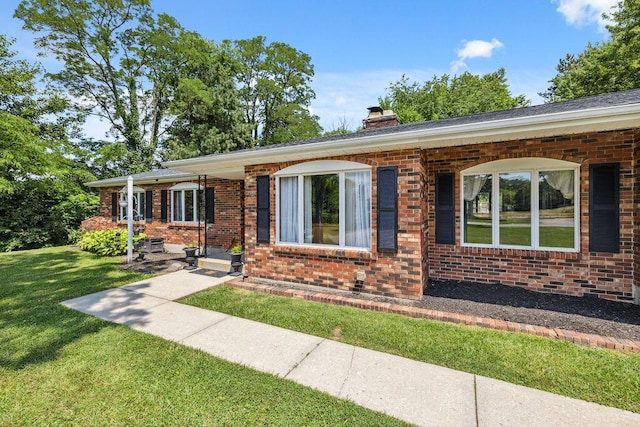 930 N Bickett Rd, Xenia, OH 45385 - ranch-style home with brick siding, a front lawn, and a chimney