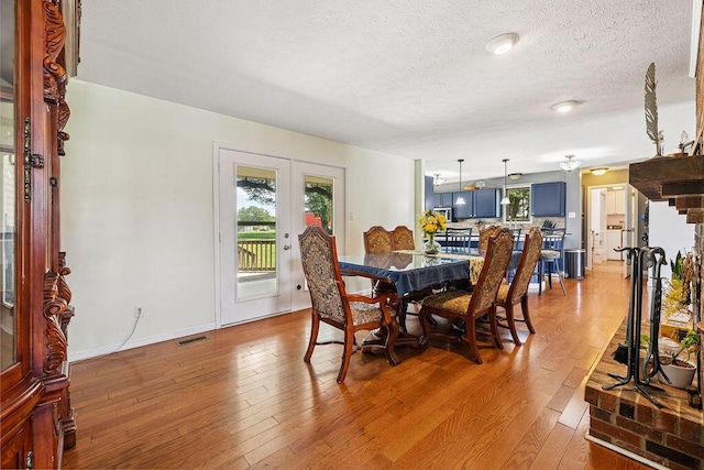 930 N Bickett Rd, Xenia, OH 45385 - dining room with french doors, light wood-style floors, plenty of natural light, and a textured ceiling