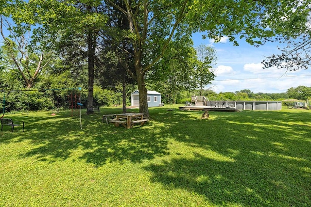 930 N Bickett Rd, Xenia, OH 45385 - view of green lawn featuring a shed, a wooden deck, and view of wooded area