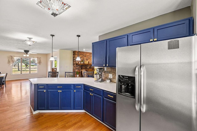 930 N Bickett Rd, Xenia, OH 45385 - kitchen with stainless steel refrigerator with ice dispenser, a peninsula, blue cabinetry, light wood-style flooring, and light countertops
