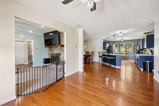 930 N Bickett Rd, Xenia, OH 45385 - living room featuring light wood-style flooring, a ceiling fan, and a brick fireplace