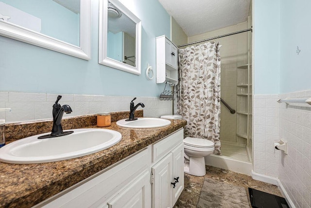 930 N Bickett Rd, Xenia, OH 45385 - bathroom with a tile shower, tile walls, double vanity, and wainscoting