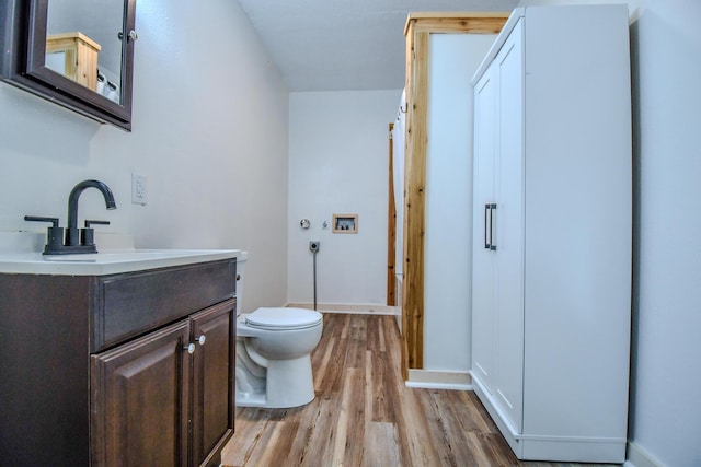 bathroom with vanity, wood-type flooring, and toilet