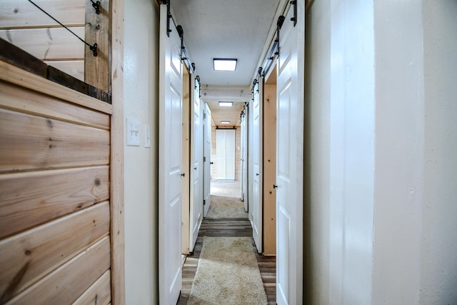 corridor featuring a barn door and hardwood / wood-style floors