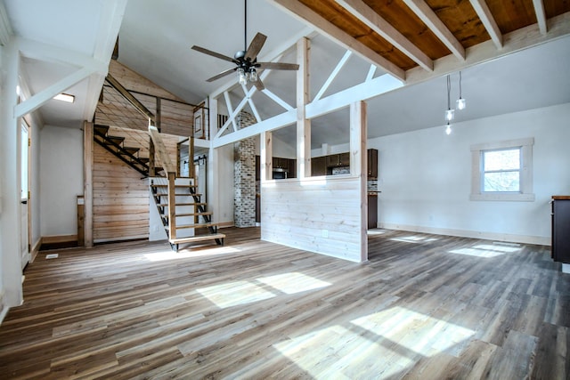 unfurnished living room with hardwood / wood-style flooring, ceiling fan, and high vaulted ceiling