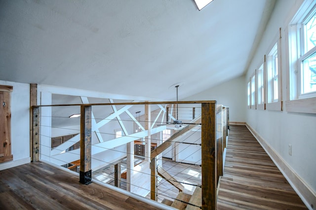 hallway featuring vaulted ceiling and dark hardwood / wood-style flooring