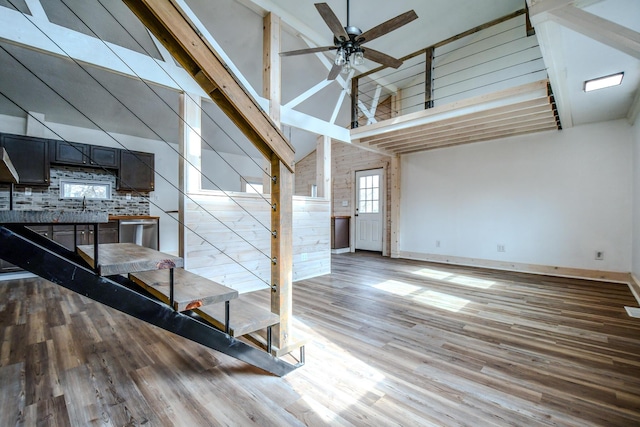 interior space featuring ceiling fan, high vaulted ceiling, and light hardwood / wood-style floors