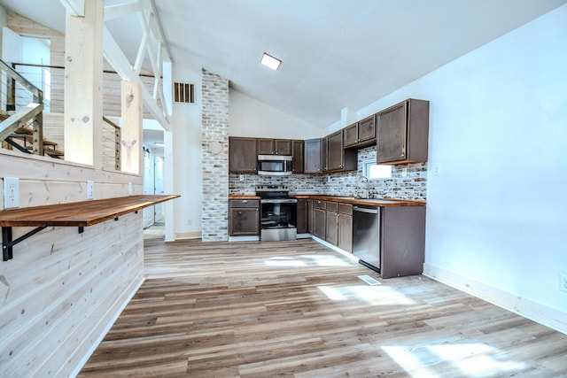 kitchen featuring tasteful backsplash, appliances with stainless steel finishes, dark brown cabinets, and light hardwood / wood-style floors