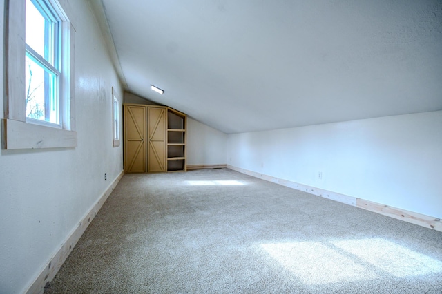 bonus room with lofted ceiling and carpet floors