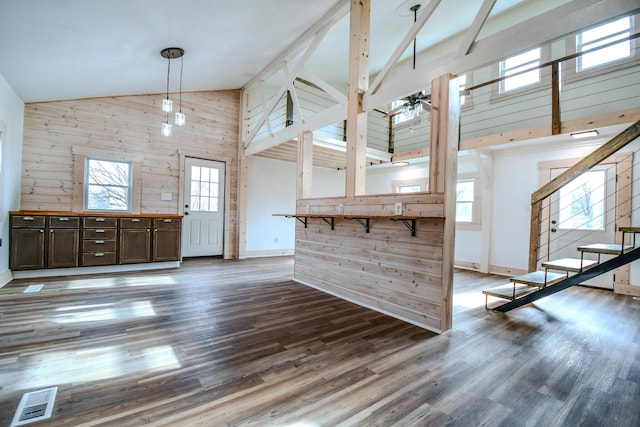 interior space featuring ceiling fan, high vaulted ceiling, dark hardwood / wood-style flooring, and wood walls