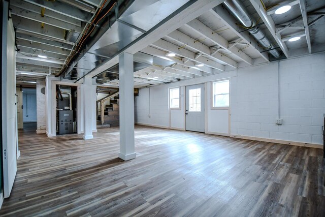 basement featuring heating unit and wood-type flooring