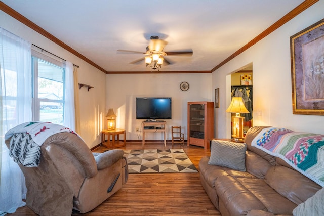 living room with hardwood / wood-style flooring, ornamental molding, and ceiling fan