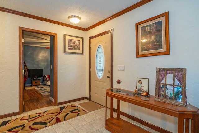 tiled entrance foyer featuring ornamental molding and a textured ceiling