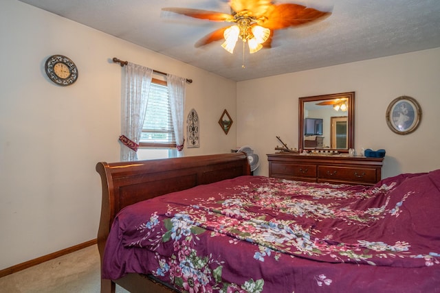 bedroom featuring ceiling fan, light colored carpet, and a textured ceiling