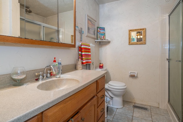 bathroom featuring a shower with shower door, vanity, toilet, tile patterned floors, and a textured ceiling