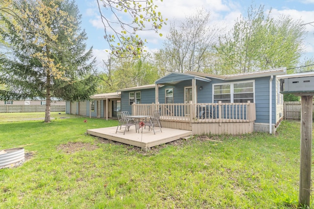 back of house featuring a lawn, a deck, and fence