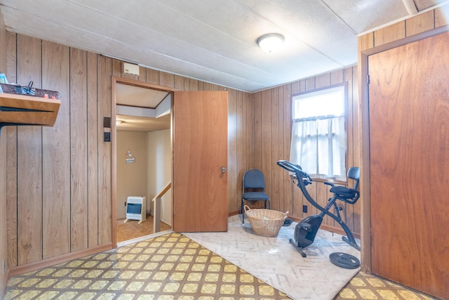 exercise room with wooden walls and tile patterned floors