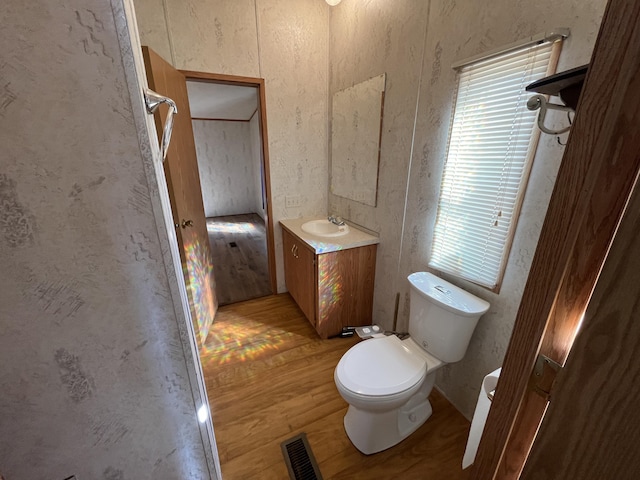 bathroom with visible vents, toilet, wood finished floors, and vanity