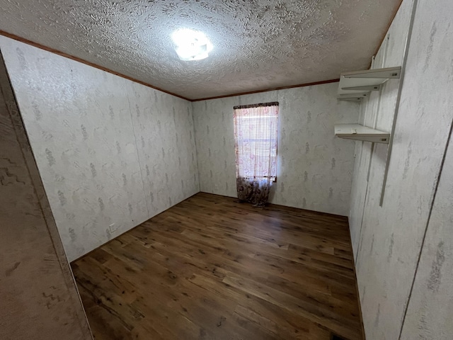 unfurnished room featuring a textured ceiling, crown molding, and wood finished floors