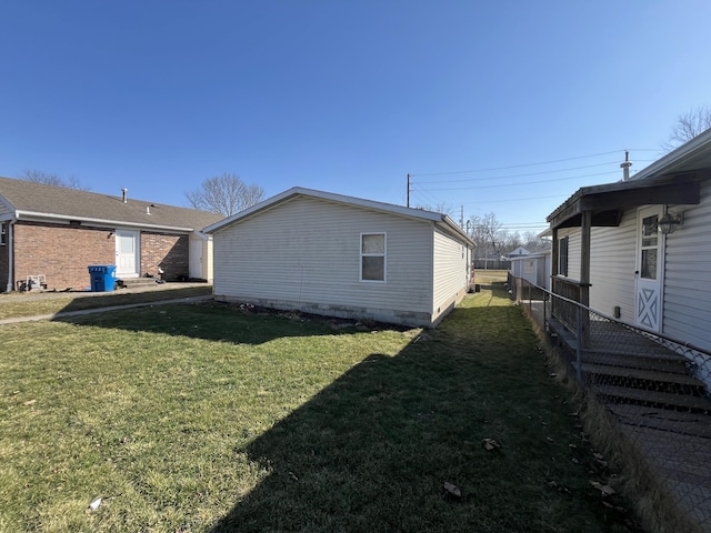 view of property exterior with a lawn and fence