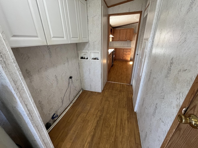 laundry room featuring dark wood-style floors, cabinet space, and hookup for a washing machine