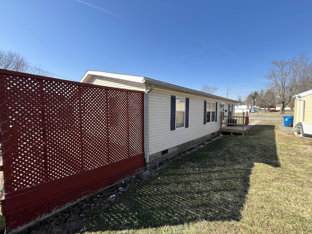 view of side of property with a lawn and crawl space