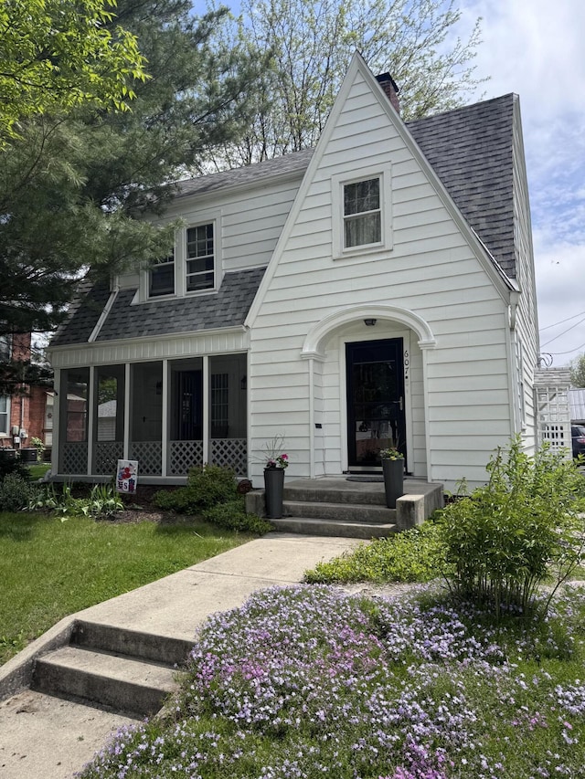 607 W S St, Saint Marys, OH 45885 - view of front of house featuring a shingled roof, a chimney, a sunroom, and a front lawn