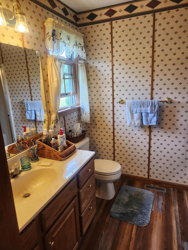 1206 Kimberly Dr, Saint Marys, OH 45885 - bathroom with wood finished floors, toilet, vanity, and wallpapered walls