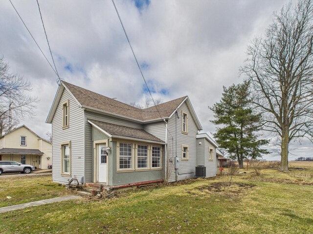 249 W Washington St, New Madison, OH 45346 - view of side of property with a lawn, a shingled roof, cooling unit, and entry steps