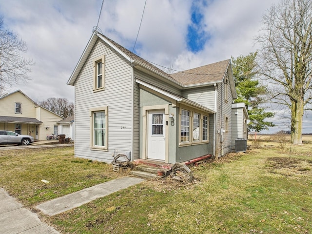 249 W Washington St, New Madison, OH 45346 - traditional-style house featuring a front yard, central AC unit, roof with shingles, and entry steps